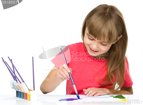 Image of Little girl is painting with gouache