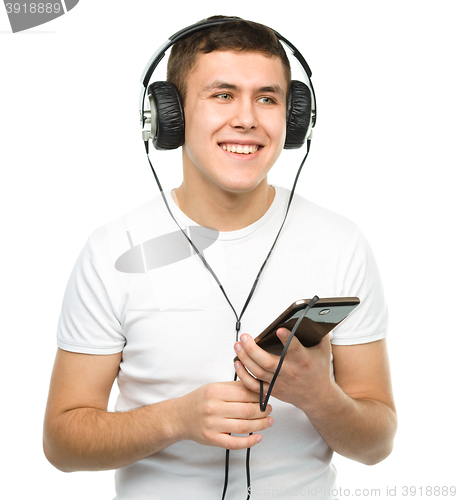 Image of Young man enjoying music using headphones