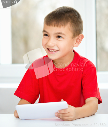 Image of Young boy is using tablet