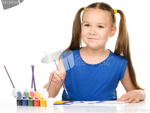 Image of Little girl is painting with gouache