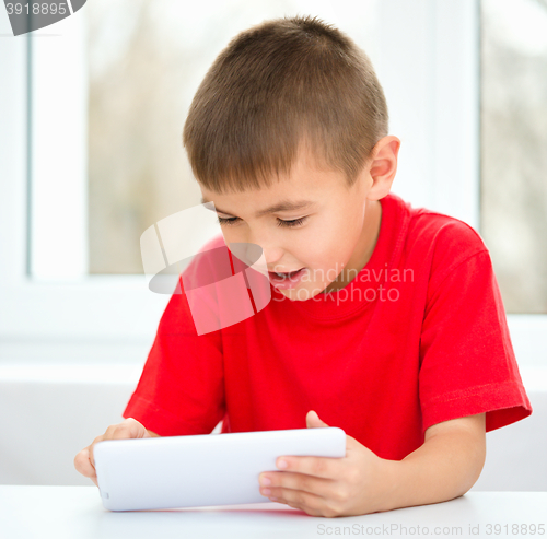 Image of Young boy is using tablet