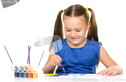 Image of Little girl is painting with gouache