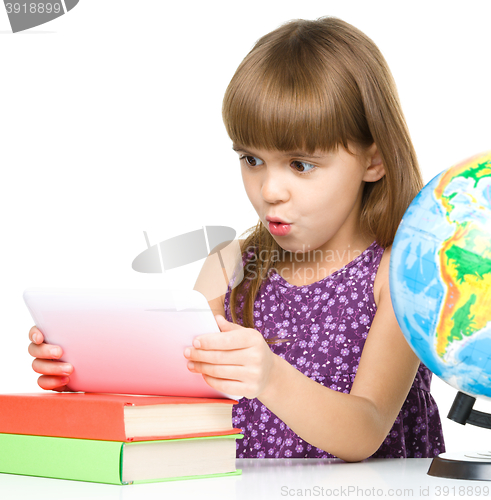 Image of Young girl is using tablet while studying