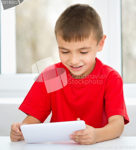 Image of Young boy is using tablet