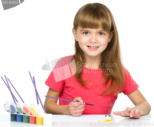 Image of Little girl is painting with gouache