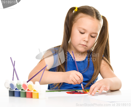 Image of Little girl is painting with gouache