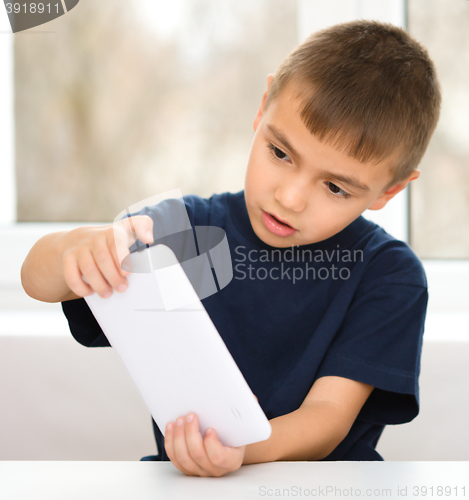 Image of Young boy is using tablet