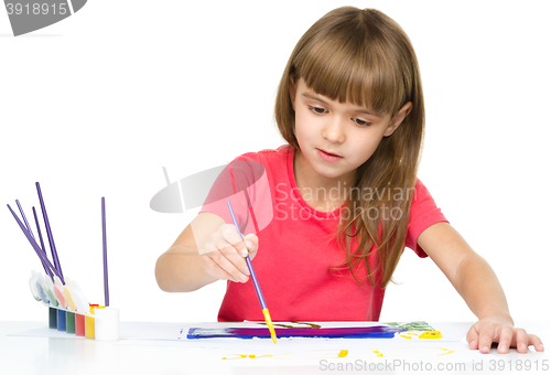 Image of Little girl is painting with gouache