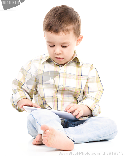 Image of Young boy is using tablet