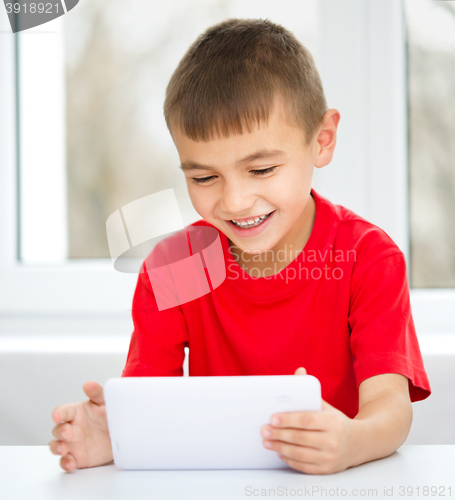 Image of Young boy is using tablet