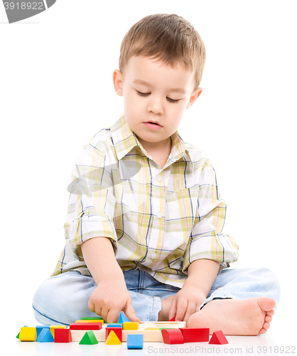 Image of Little boy is playing with toys
