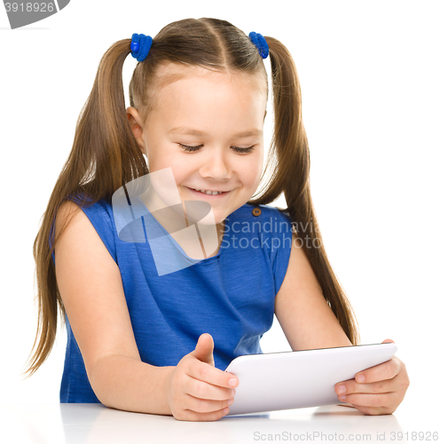 Image of Young cheerful girl is using tablet