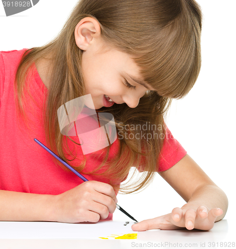 Image of Little girl is painting with gouache