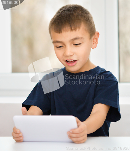 Image of Young boy is using tablet