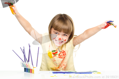 Image of Portrait of a cute girl playing with paints