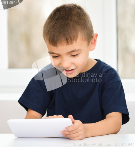 Image of Young boy is using tablet