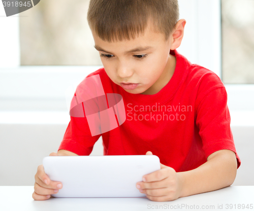 Image of Young boy is using tablet