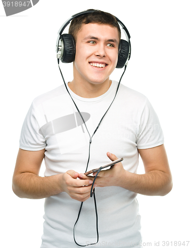 Image of Young man enjoying music using headphones