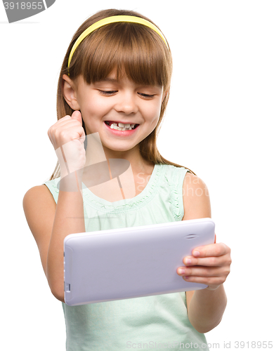 Image of Young girl is playing game using tablet
