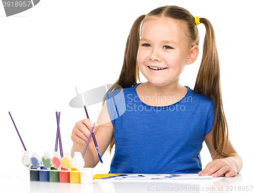 Image of Little girl is painting with gouache