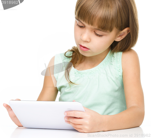 Image of Young girl is using tablet while studying