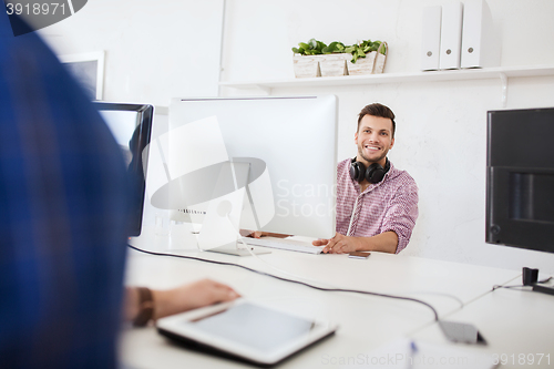 Image of creative man with headphones and computer