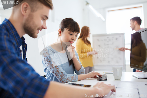 Image of creative team with blueprint at office