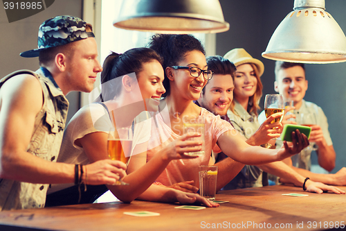 Image of happy friends with smartphone taking selfie at bar
