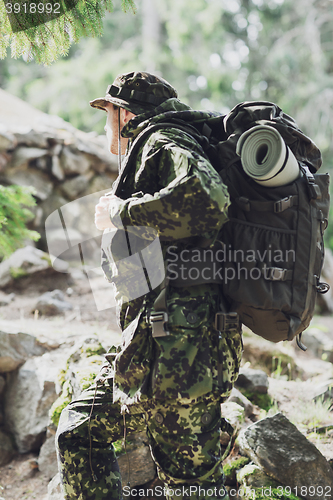 Image of young soldier with backpack in forest