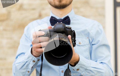 Image of close up of male photographer with digital camera