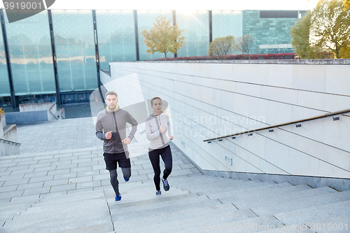 Image of happy couple running upstairs on city stairs