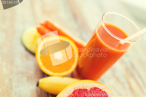 Image of close up of fresh juice glass and fruits on table