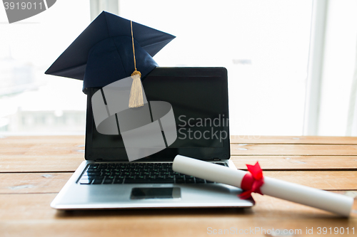 Image of close up of laptop with mortarboard and diploma