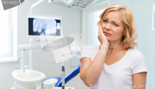Image of unhappy woman suffering toothache at dental office