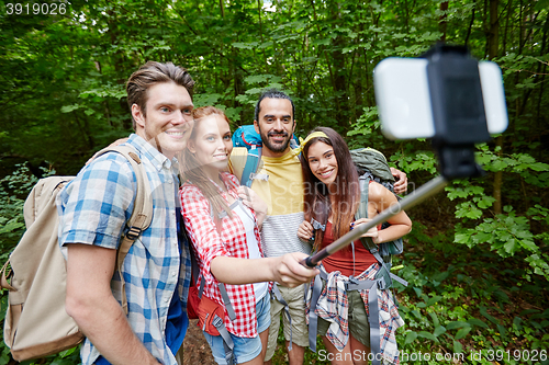 Image of friends with backpack taking selfie by smartphone