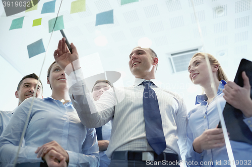 Image of smiling business people with marker and stickers