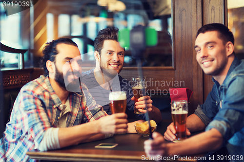 Image of friends taking selfie and drinking beer at bar