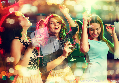 Image of smiling friends with glasses of champagne in club