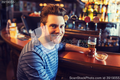 Image of happy man drinking beer at bar or pub