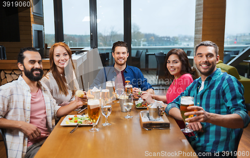 Image of friends dining and drinking beer at restaurant