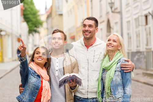 Image of group of friends with city guide exploring town