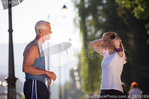 Image of jogging couple planning running route  and setting music