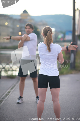 Image of couple warming up before jogging