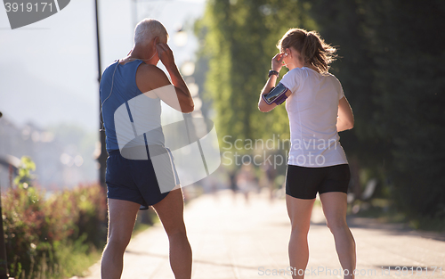 Image of jogging couple planning running route  and setting music