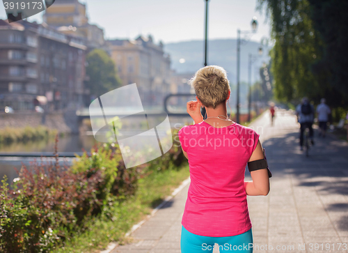 Image of jogging woman setting phone before jogging