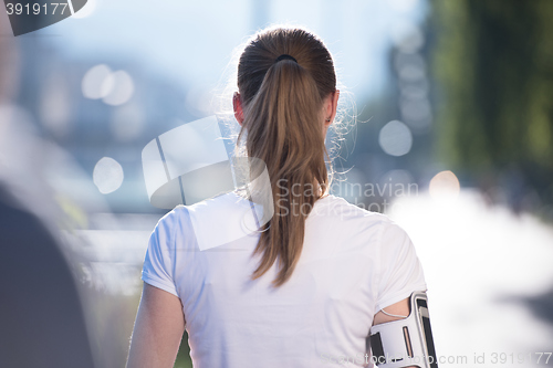 Image of jogging woman setting phone before jogging