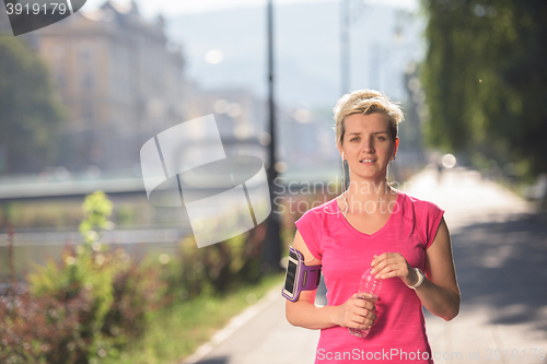 Image of sporty woman running  on sidewalk