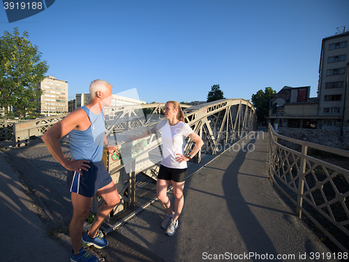 Image of jogging couple planning running route  and setting music