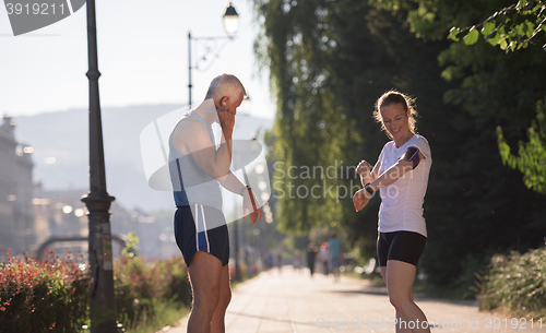 Image of jogging couple planning running route  and setting music