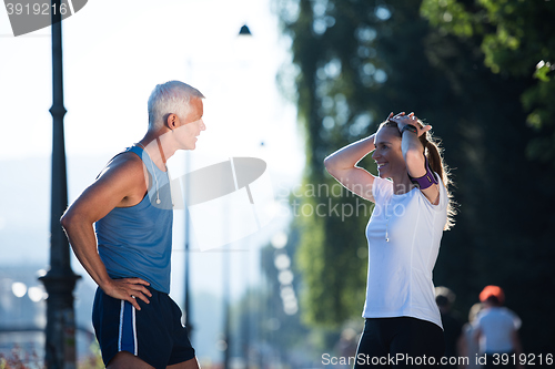 Image of jogging couple planning running route  and setting music